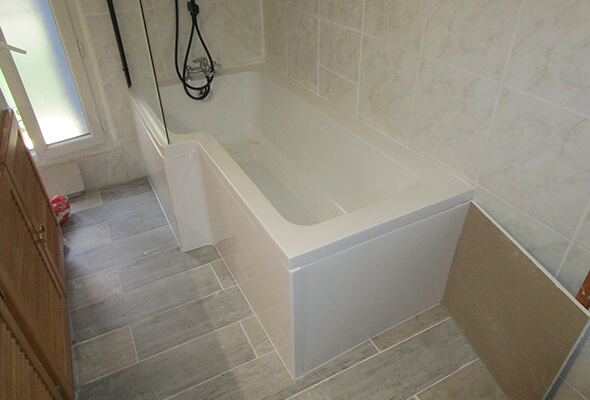 Salle de bain rénovée avec nouveau carrelage et baignoire à Gignac.